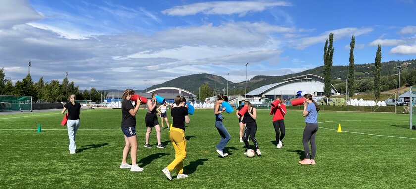 BUSK-elever leker på en fotballbane. - Klikk for stort bilde